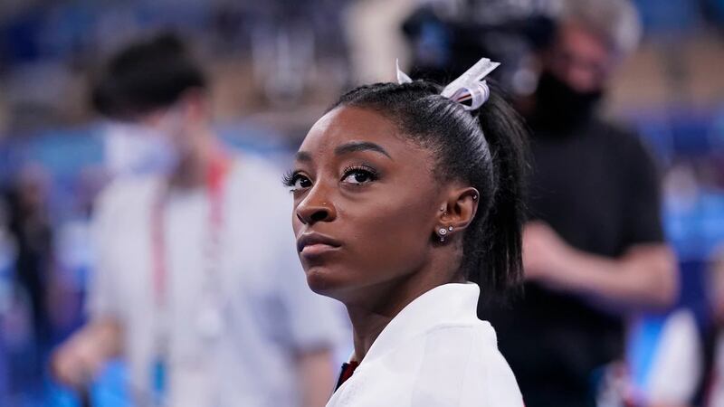 Simone Biles, of the United States, waits for her turn to perform during the artistic...