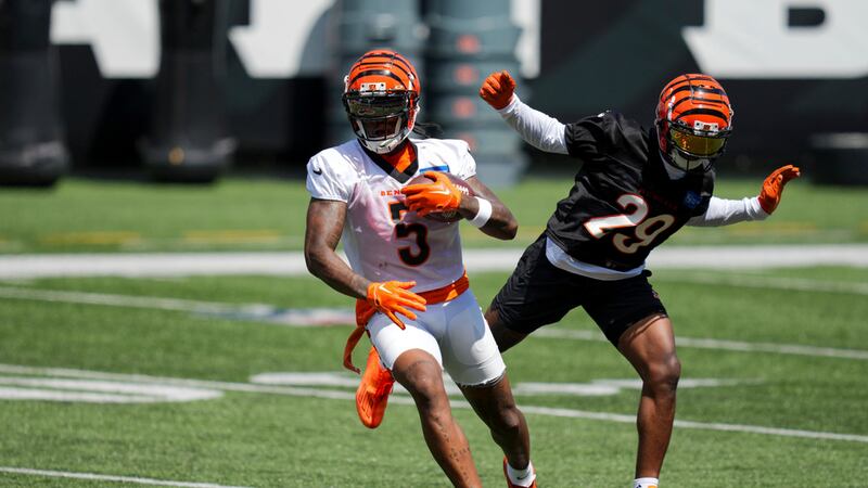 Cincinnati Bengals' Tee Higgins, left, makes a catch against cornerback Cam Taylor-Britt in a...