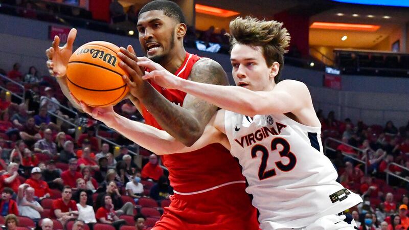 Louisville forward Malik Williams (5) battles Virginia guard Kody Stattmann (23) for a rebound...